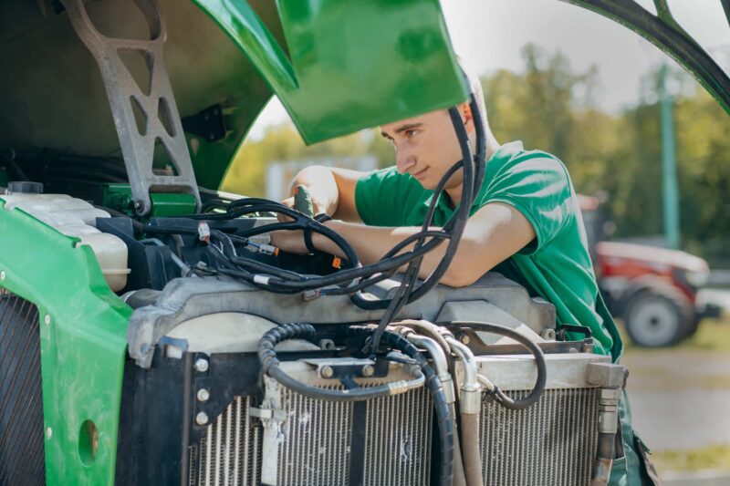 Technicien intervenant sur le circuit hydraulique d’un tracteur