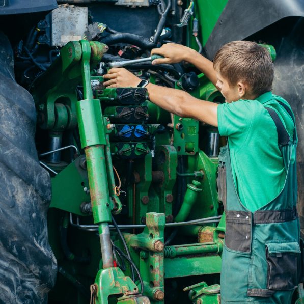 Technicien intervenant sur le moteur d’un tracteur