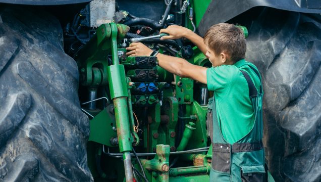 Technicien intervenant sur le moteur d’un tracteur